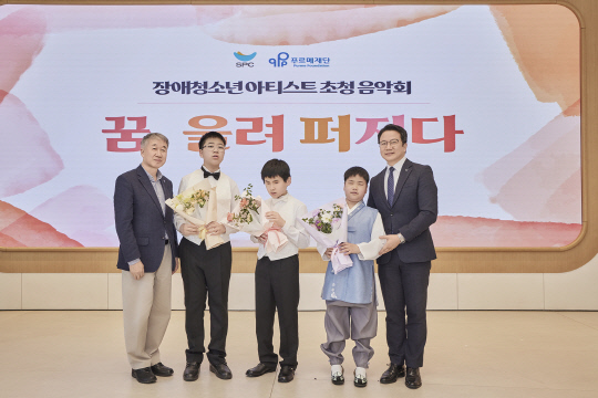 지난 15일 서울시 도곡동 SPC2023에 위치한 '워크샵 바이 배스킨라빈스'에서 진행된 'SPC행복한펀드' 기부 약정식에서 백경학(왼쪽) 푸르메재단 상임대표와 백승훈(오른쪽) SPC행복한재단 사무국장이 공연을 펼친 장애 청소년들과 기념촬영을 하고 있다. SPC그룹 제공